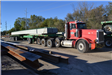Truck moving bridge support beams into position
