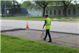 RCOC intern Jacob Barth measuring the length of an 8 Mile road spot resurfacing section
