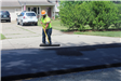 Worker spreads excess asphalt during Benstein Rd. paving in Commerce Charter Township