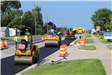Rollers on freshly paved Walton Blvd. with paver in the background in Waterford Township