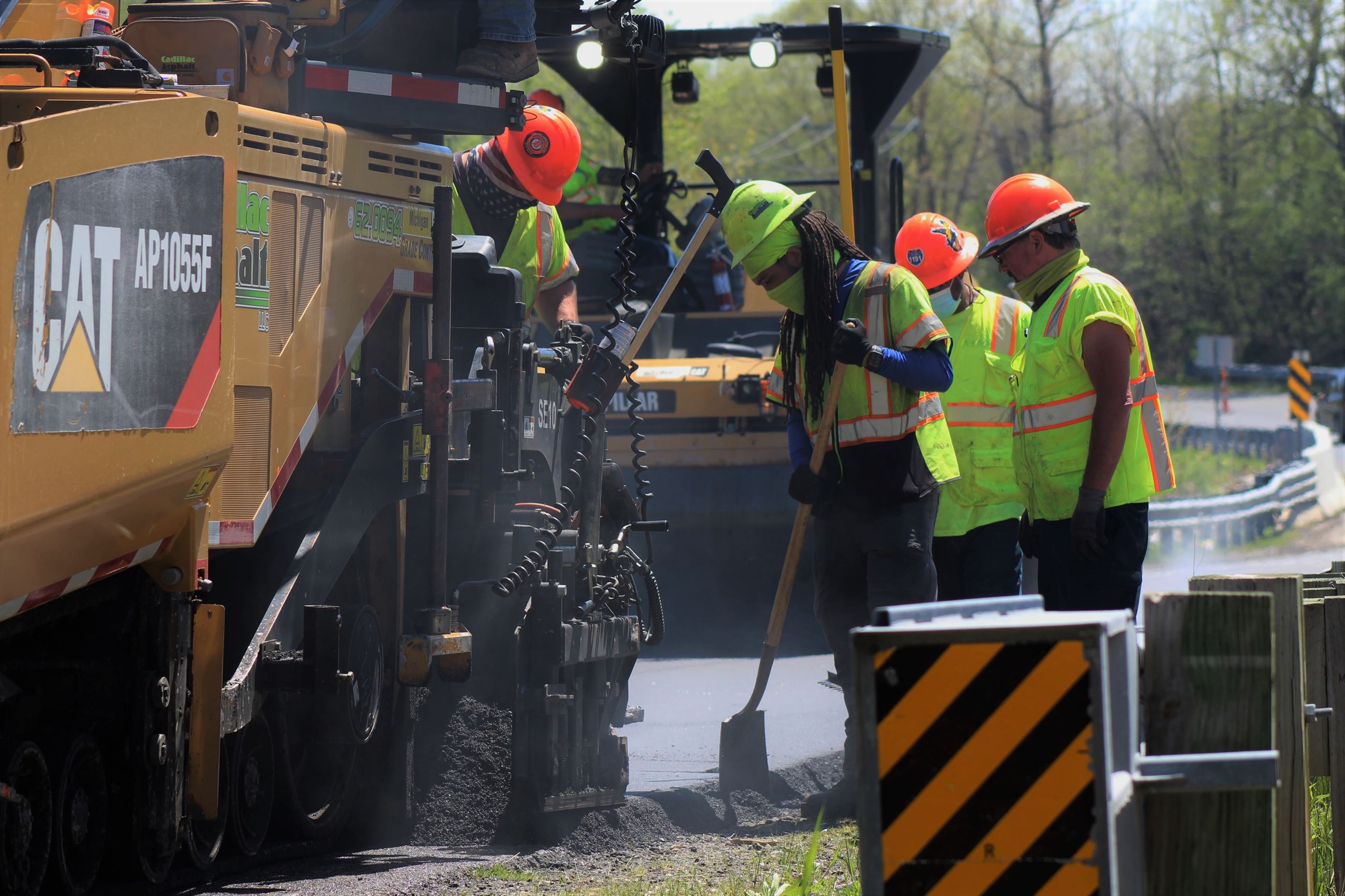 Construction Worker Uses Shovel After Asphalt Has Been Laid