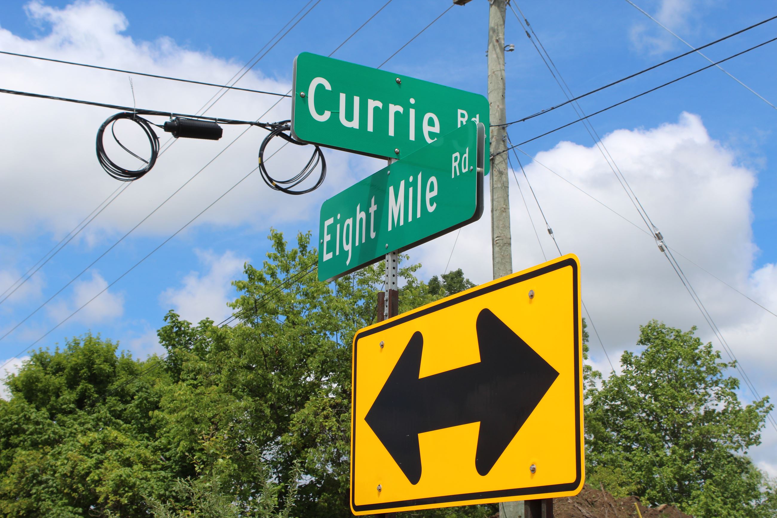 8 Mile Road and Currie Road intersection street sign in Lyon Township