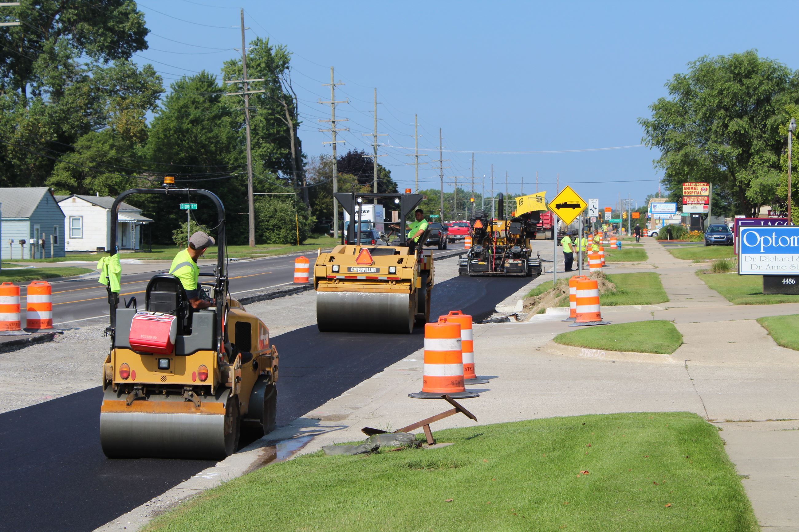 Rollers on freshly paved Walton Blvd. with paver in the background in Waterford Township